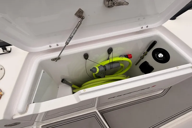 Slide: The Image of Storage compartment of 2021 Axopar 37 XC Cross Cabin with tools and hose. - 9