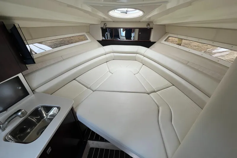 Slide: The Image of Interior of 2016 Monterey 295 Sport Yacht with plush seating and compact kitchenette. - 9
