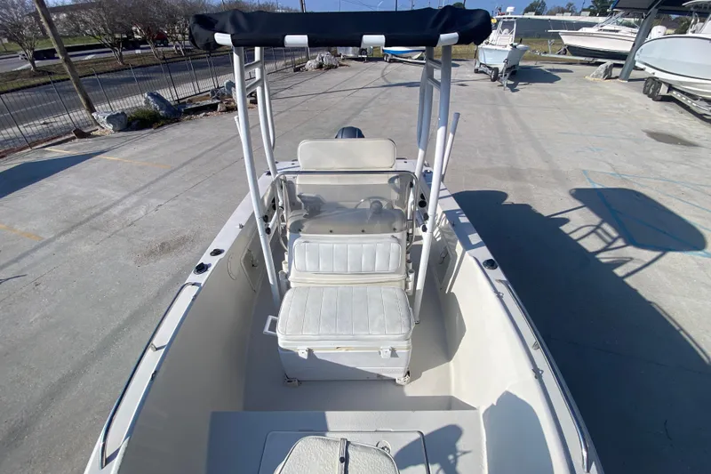 Slide: The Image of 1996 Pro-Line 170 Center Console boat with seating and canopy, parked on concrete. - 15