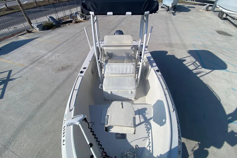 Slide: The Image of 1996 Pro-Line 170 Center Console boat with seating and canopy, parked on concrete. - 19