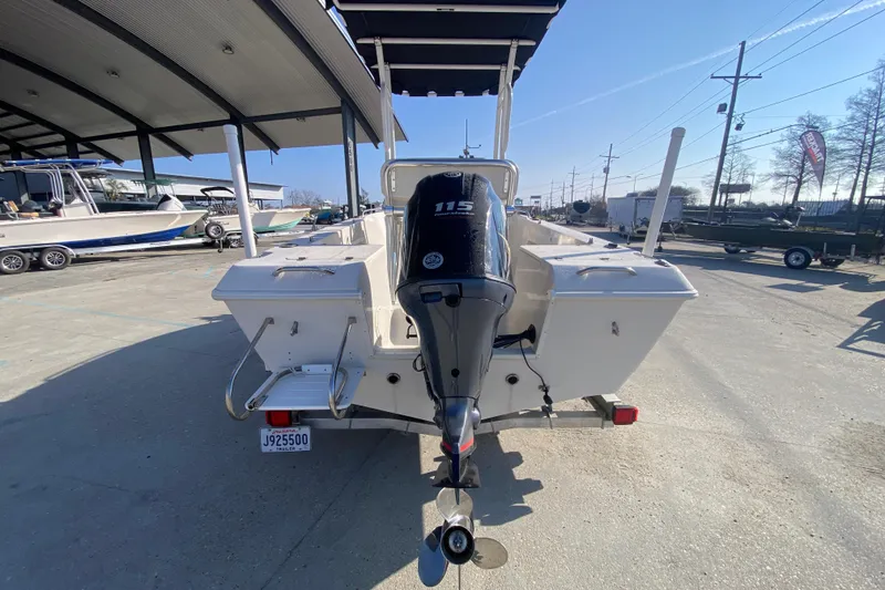 Slide: The Image of 1996 Pro-Line 170 Center Console boat with 115 HP outboard motor, parked outdoors. - 5