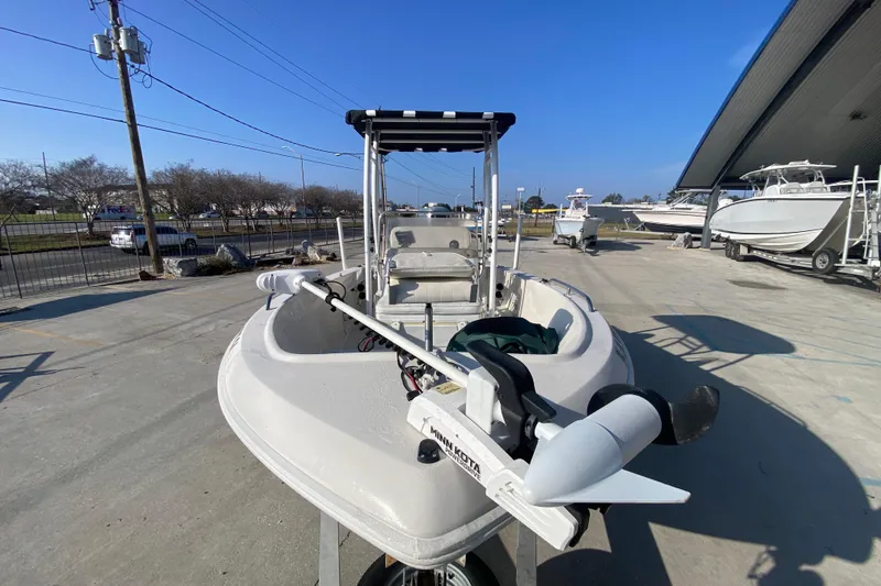 Slide: The Image of 1996 Pro-Line 170 Center Console boat with trolling motor, parked outdoors under clear blue sky. - 9