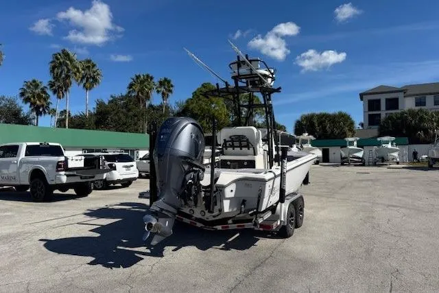 Slide: The Image of 2023 Pathfinder 2500 Hybrid boat on trailer, parked outdoors under a clear blue sky. - 2