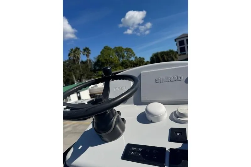 Slide: The Image of 2023 Pathfinder 2500 Hybrid boat dashboard with Yamaha steering and Simrad controls. - 9