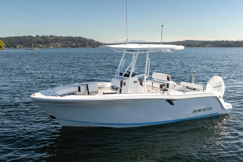 The Image of 2024 Blackfin 222 CC boat on a serene lake with scenic background. - 0