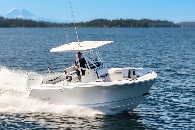 Slide: The Image of 2024 Blackfin 222 CC boat cruising on open water under clear blue skies. - 1