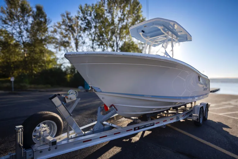 Slide: The Image of 2024 Blackfin 222 CC boat on trailer, parked near a scenic waterfront. - 10