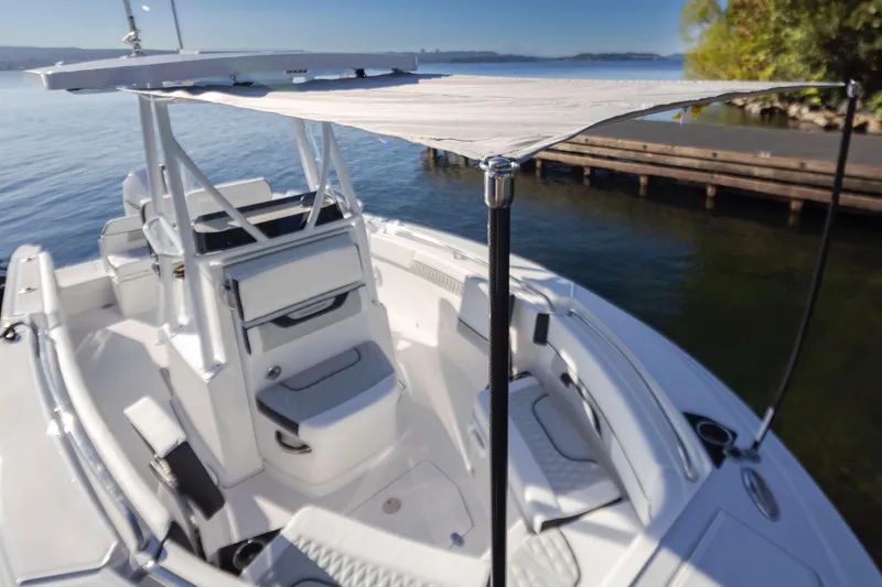 Slide: The Image of 2024 Blackfin 222 CC boat with canopy, docked on calm water. - 12