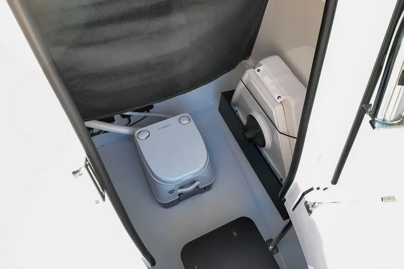 Slide: The Image of 2024 Blackfin 222 CC boat interior with compact marine toilet and storage area. - 28
