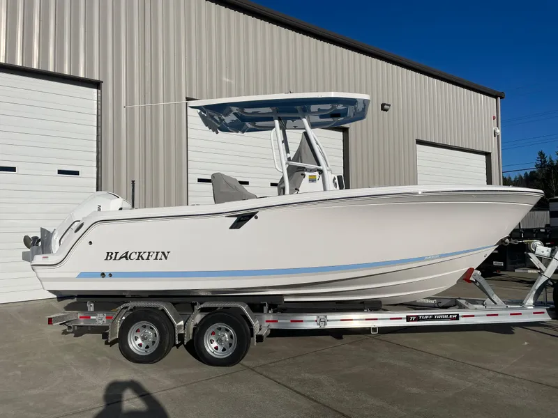Slide: The Image of 2024 Blackfin 222 CC boat on trailer, parked outside a warehouse. - 33