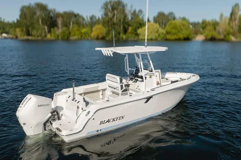 Slide: The Image of 2024 Blackfin 222 CC boat on a serene lake with lush greenery. - 9