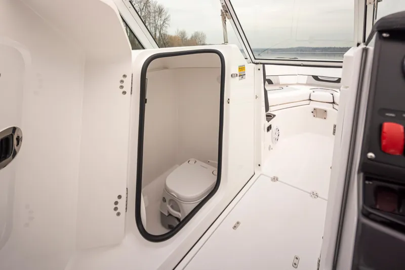 Slide: The Image of 2024 Blackfin 232DC boat interior with a compact marine toilet. - 18