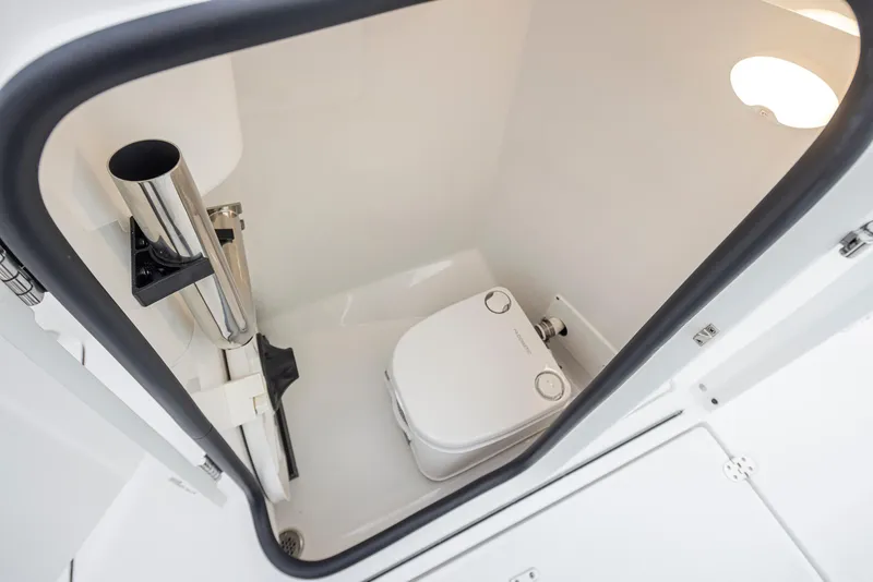 Slide: The Image of 2024 Blackfin 232DC boat interior with compact marine toilet and storage space. - 19