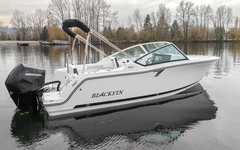 Slide: The Image of 2024 Blackfin 232DC Dual Console boat on calm water, featuring sleek design and Mercury engine. - 3