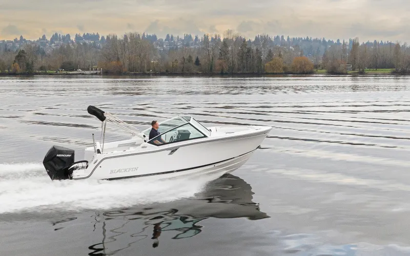 Slide: The Image of 2024 Blackfin 232DC Dual Console boat cruising on a serene lake. - 36