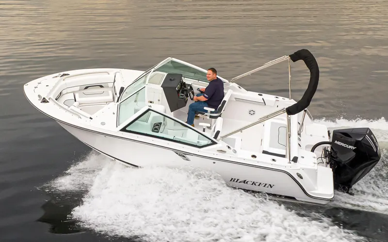 Slide: The Image of 2024 Blackfin 232DC Dual Console boat cruising on water. - 5