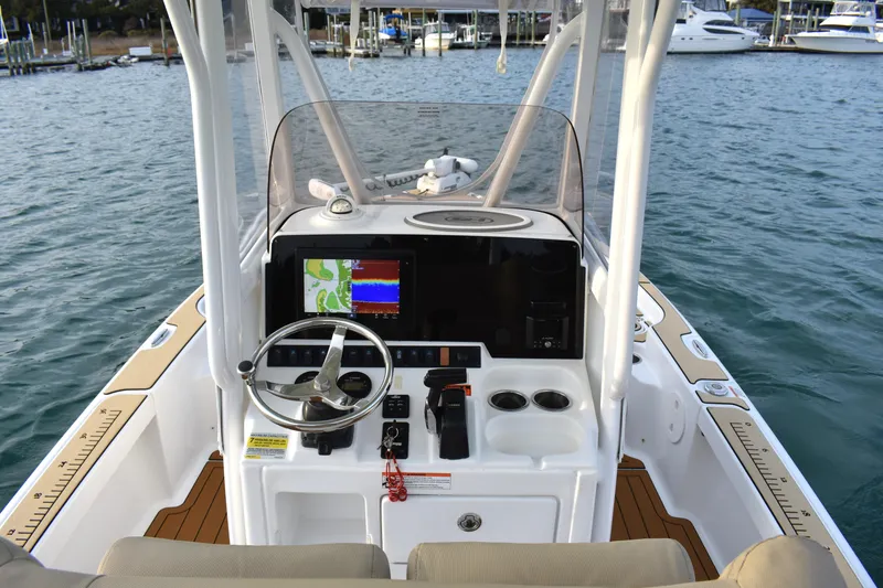 Slide: The Image of 2018 Sea Hunt BX 22 BR boat console with steering wheel and navigation display on water. - 17