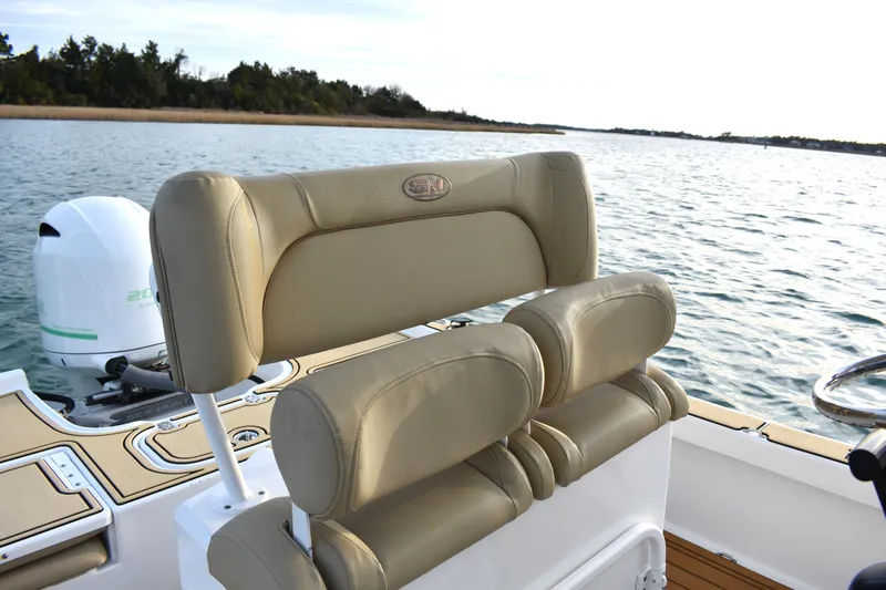 Slide: The Image of 2018 Sea Hunt BX 22 BR boat with tan seating and outboard motor on calm water. - 18