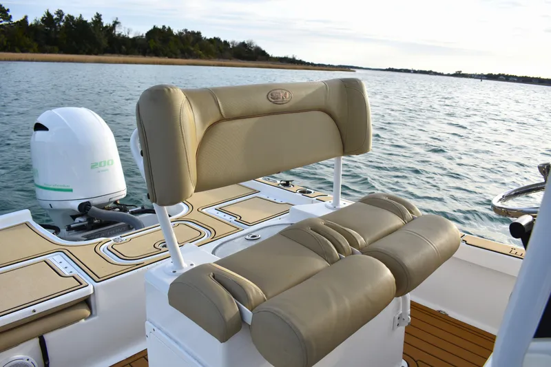 Slide: The Image of 2018 Sea Hunt BX 22 BR boat with tan seating and outboard motor on water. - 19