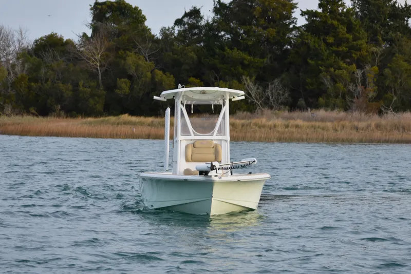 Slide: The Image of 2018 Sea Hunt BX 22 BR boat cruising on a calm lake with forested shoreline. - 2