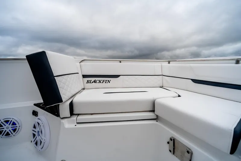 Slide: The Image of 2023 Blackfin 252 CC boat with luxurious white seating and overcast sky. - 18