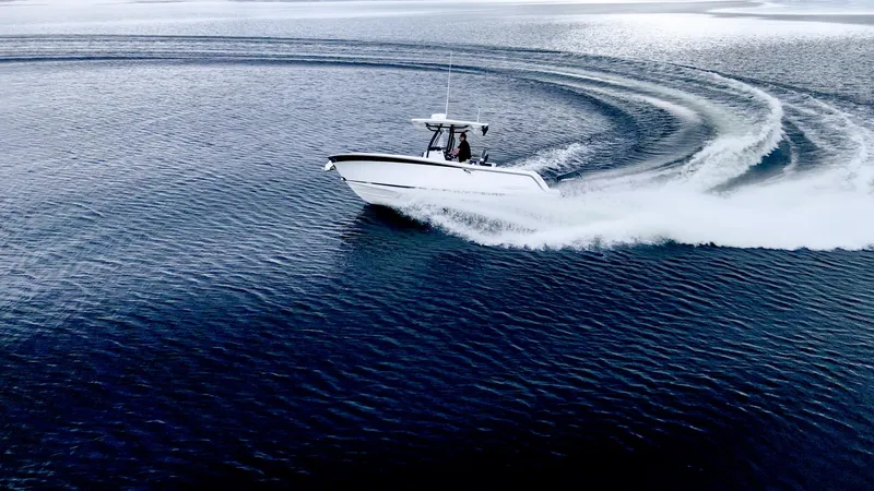 Slide: The Image of 2023 Blackfin 252 CC boat making a sharp turn on open water. - 29