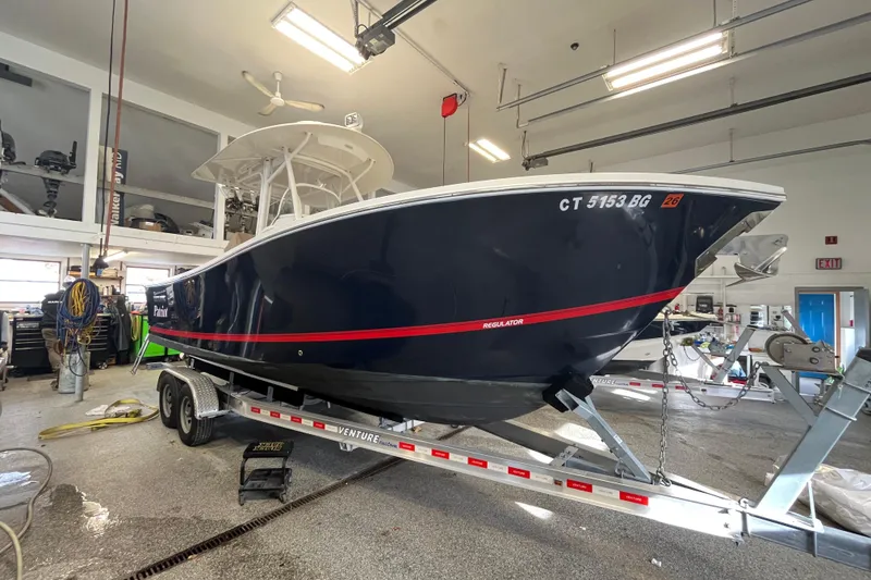 Slide: The Image of 2015 Regulator 25 boat on trailer in a garage setting. - 10