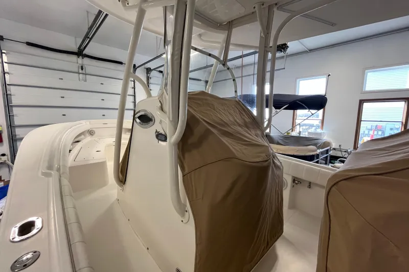 Slide: The Image of 2015 Regulator 25 boat interior with protective covers in a garage setting. - 12