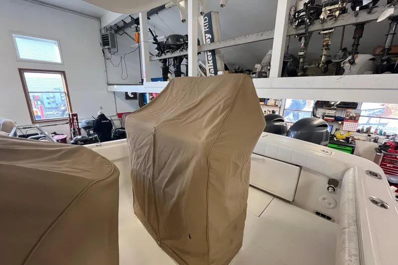 Slide: The Image of 2015 Regulator 25 boat interior with covered console in a workshop setting. - 13