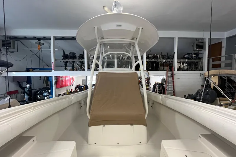 Slide: The Image of 2015 Regulator 25 boat in indoor storage, showcasing helm and seating area. - 14