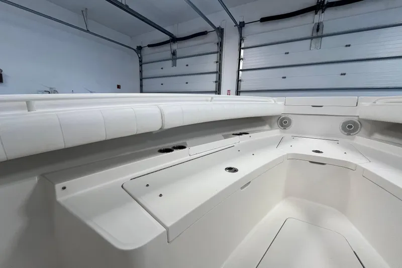 Slide: The Image of 2015 Regulator 25 boat interior with white seating and storage compartments. - 16