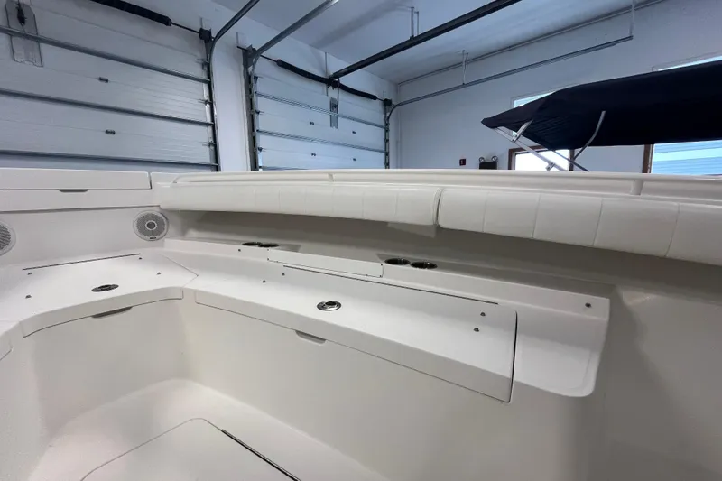 Slide: The Image of 2015 Regulator 25 boat interior with white seating and storage compartments. - 17