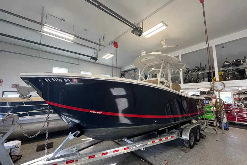 The Image of 2015 Regulator 25 boat on trailer in a garage setting. - 2
