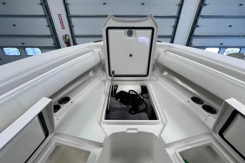 Slide: The Image of 2015 Regulator 25 boat interior with open storage compartment in a garage setting. - 20