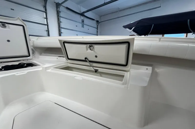 Slide: The Image of 2015 Regulator 25 boat interior with open storage compartments in a garage setting. - 22