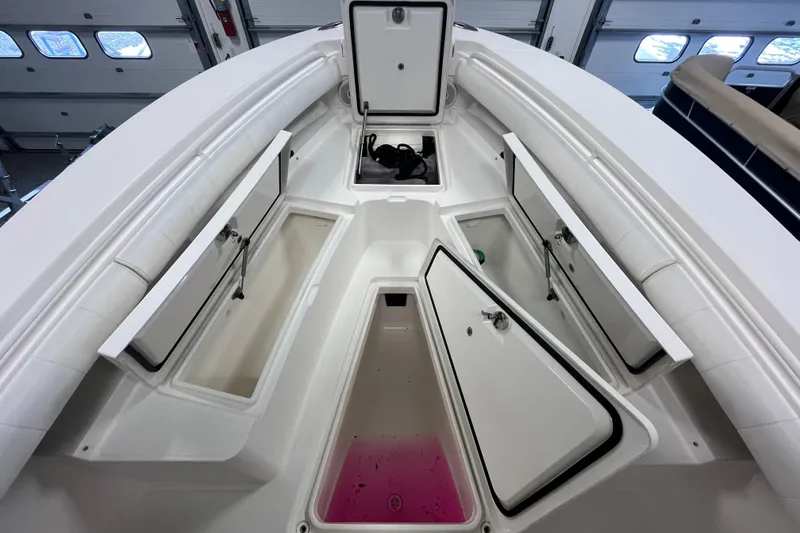 Slide: The Image of 2015 Regulator 25 boat interior with open storage compartments in a garage setting. - 23