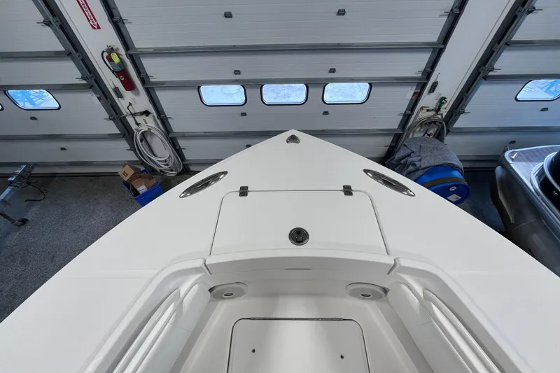 Slide: The Image of 2015 Regulator 25 boat bow in a garage, showcasing storage compartments. - 24