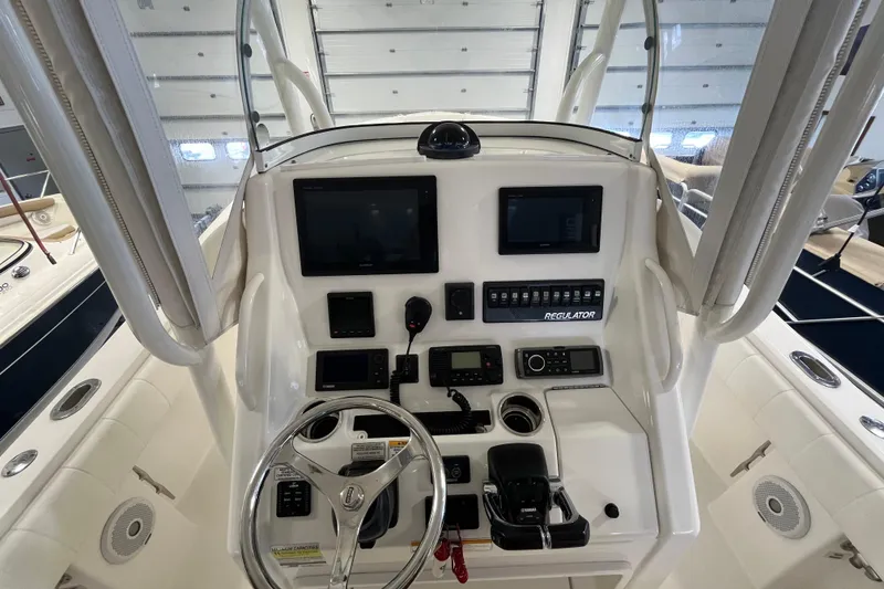 Slide: The Image of 2015 Regulator 25 boat dashboard with steering wheel and electronic controls. - 34