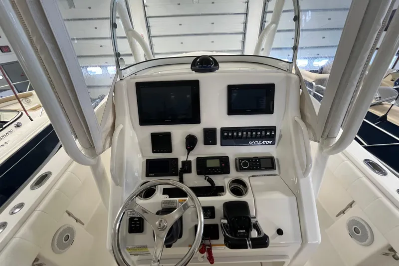 Slide: The Image of 2015 Regulator 25 boat dashboard with steering wheel and electronic controls. - 35