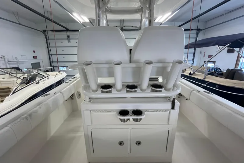 Slide: The Image of 2015 Regulator 25 boat interior with rod holders and storage compartments in a showroom. - 41