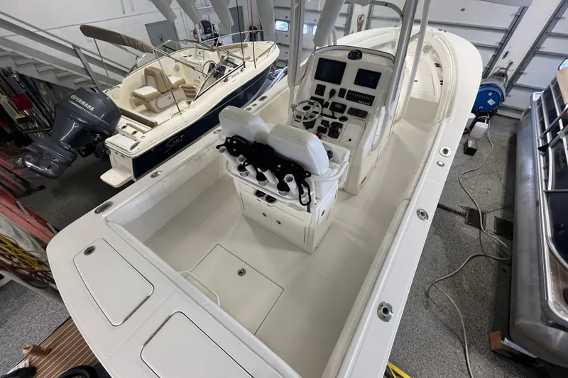 Slide: The Image of 2015 Regulator 25 boat in garage, featuring center console and dual seating. - 47