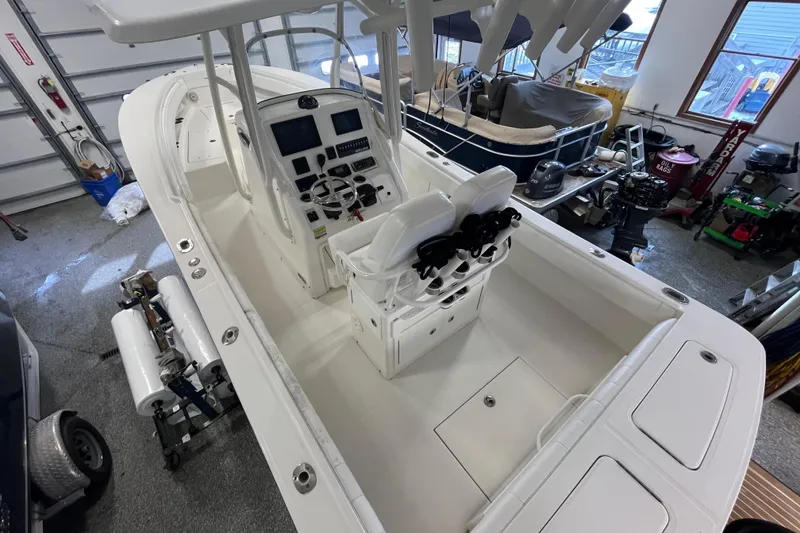 Slide: The Image of 2015 Regulator 25 boat in garage, featuring dual seats and modern control panel. - 48