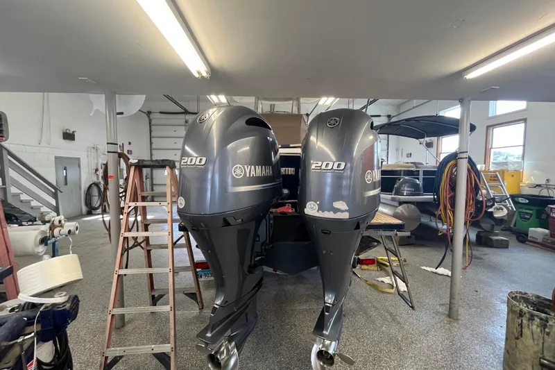 Slide: The Image of Twin Yamaha 200 outboard engines on a 2015 Regulator 25 boat in a garage. - 5