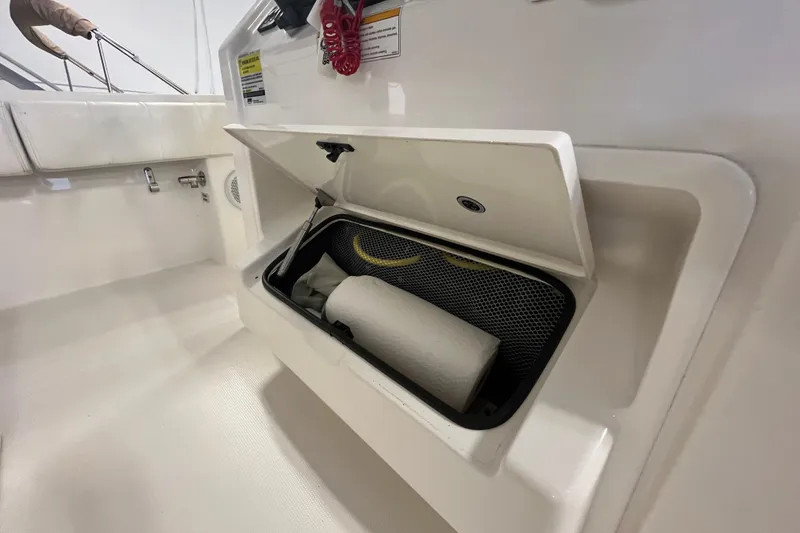 Slide: The Image of 2015 Regulator 25 boat storage compartment with open hatch and stored items. - 50