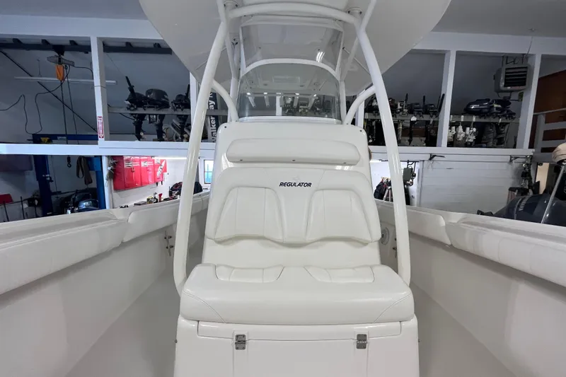 Slide: The Image of 2015 Regulator 25 boat interior with white seating in a garage setting. - 52