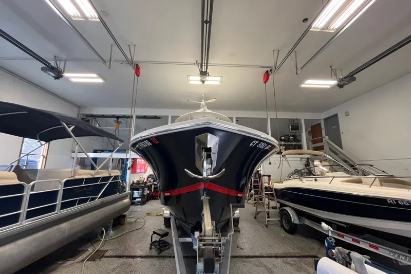Slide: The Image of 2015 Regulator 25 boat in a garage with other boats. - 60