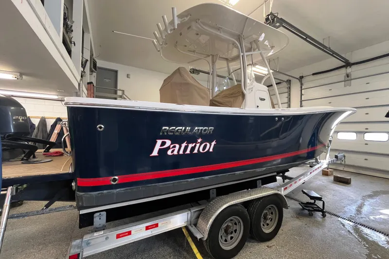Slide: The Image of 2015 Regulator 25 boat named "Patriot" on trailer in garage. - 9