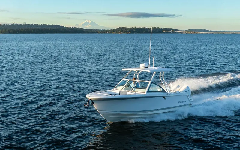 Slide: The Image of 2024 Blackfin 252 DC cruising on a serene lake with distant mountains. - 1