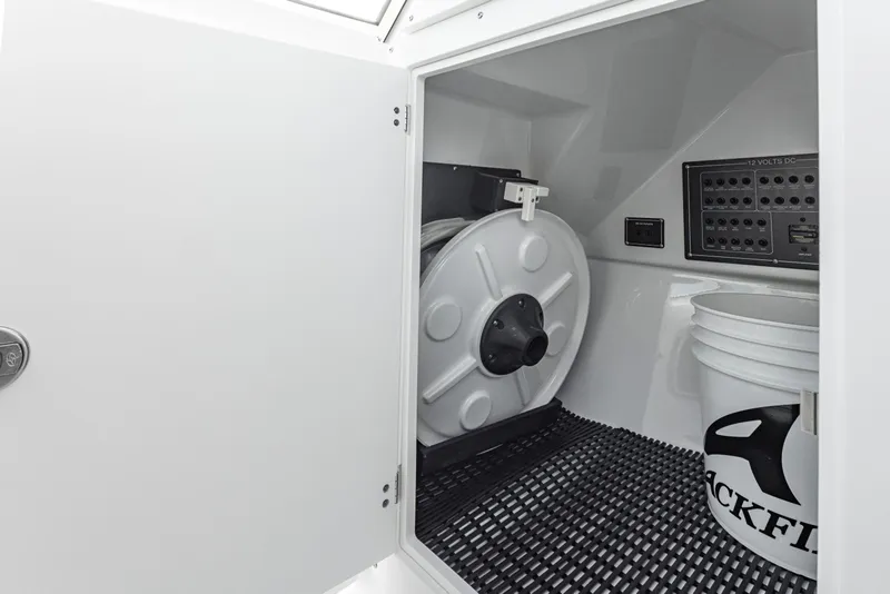 Slide: The Image of 2024 Blackfin 252 DC storage compartment with equipment and Blackfin-branded bucket. - 29