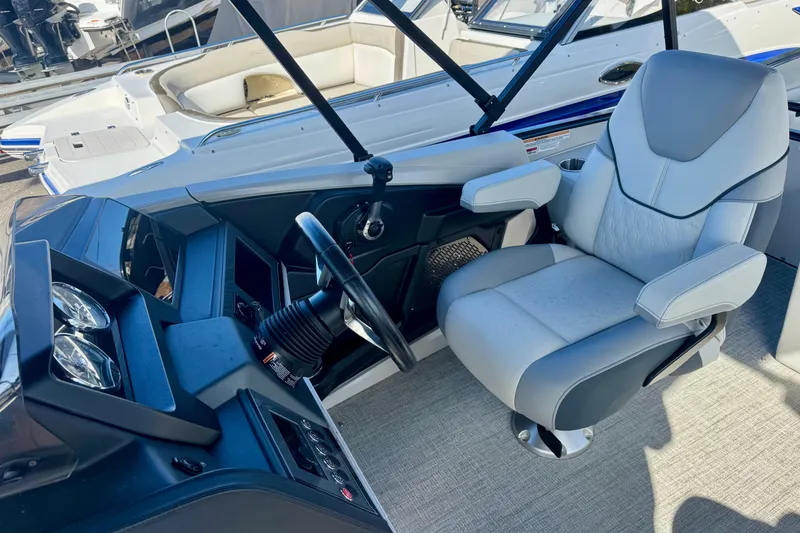 Slide: The Image of 2026 Avalon Catalina Platinum Versatile Rear Bench boat interior with captain's chair and dashboard. - 30